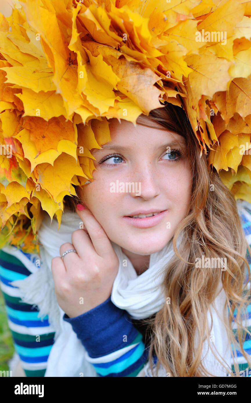 herbstliche Frau auf Blätter, Kranz auf Kopf Stockfoto