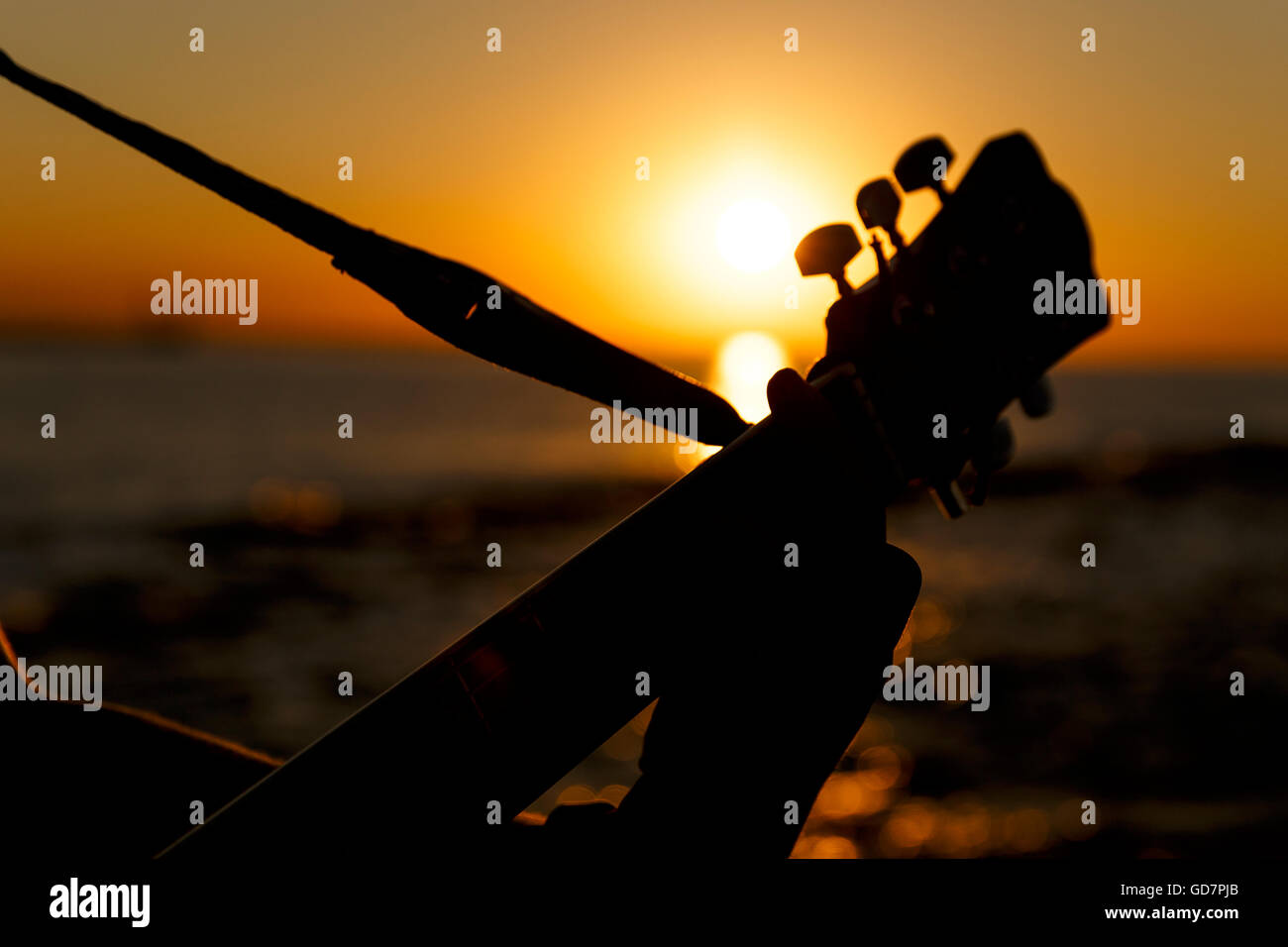 Junger Mann, eine Gitarre bei Sonnenuntergang (Soft-Fokus) Stockfoto