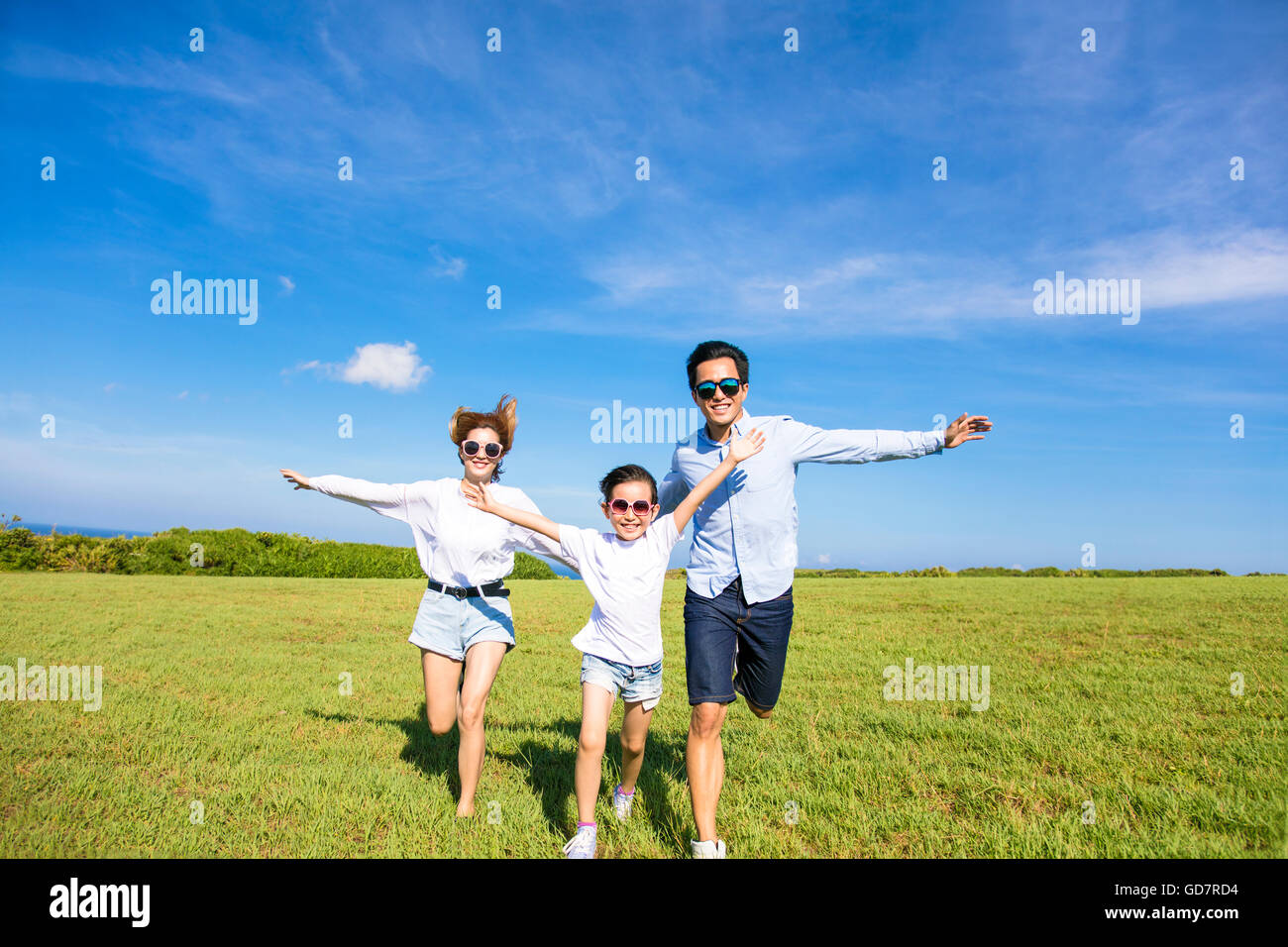 Glückliche Familie zusammen laufen auf dem Rasen Stockfoto