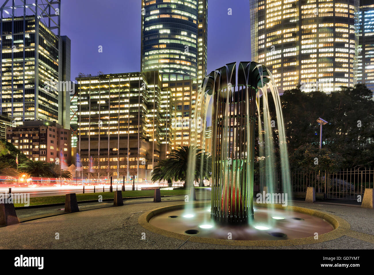 Sydney City Bürogebäude Türme bei Sonnenuntergang hinter verschwommen Wasser-Brunnen in der Nähe von Royal Botanic Garden. Beleuchtete Bürofenster Stockfoto