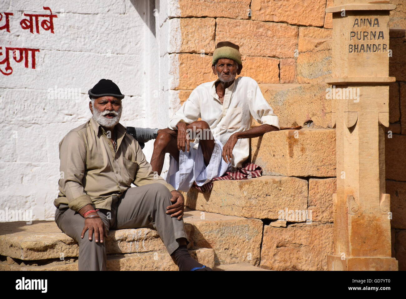 Zwei indische Männer sitzen auf Steinstufen in Jaisalmer, Rajasthan, Indien Stockfoto