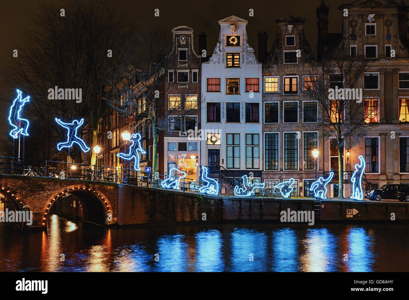 Leichte Festival Amsterdam, eine leichte Figur macht einen Salto mit Dekor Amsterdamer Grachtenhäuser und Brücke Stockfoto