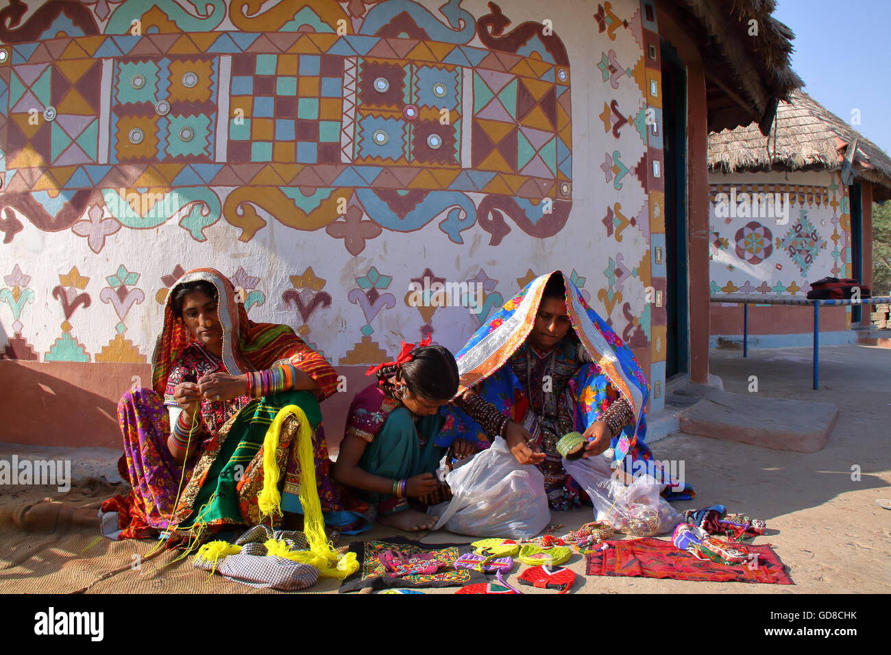 Stammes-Frauen vor ihrem Haus (Bhunga) in einem Dorf in der Nähe von Bhuj, Gujarat, Indien Stockfoto
