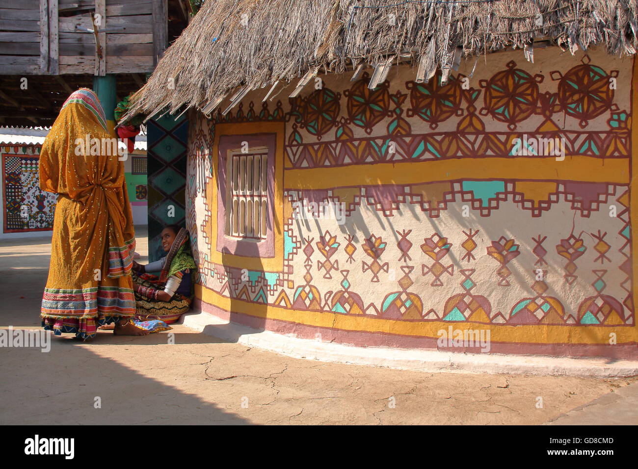Stammes-Frauen vor ihrem Haus (Bhunga) in Lydia, Dorf in der Nähe von Bhuj, Gujarat, Indien Stockfoto