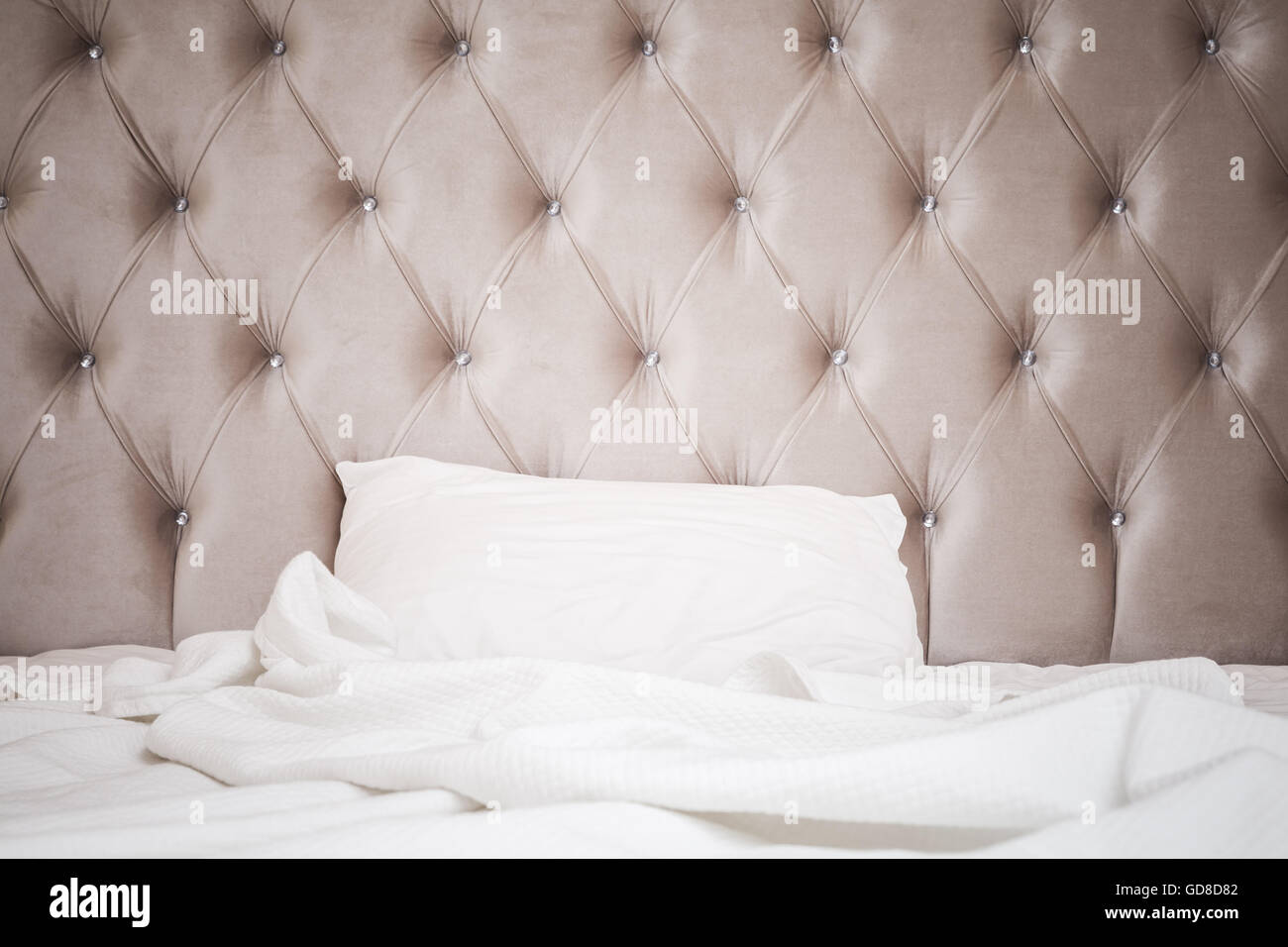 Luxus leeren Schlafzimmer Inneren Fragment, weiche rosa Kopfteil, weiße Bettwäsche Laken und Kissen lag auf weiten leeren Bett Stockfoto