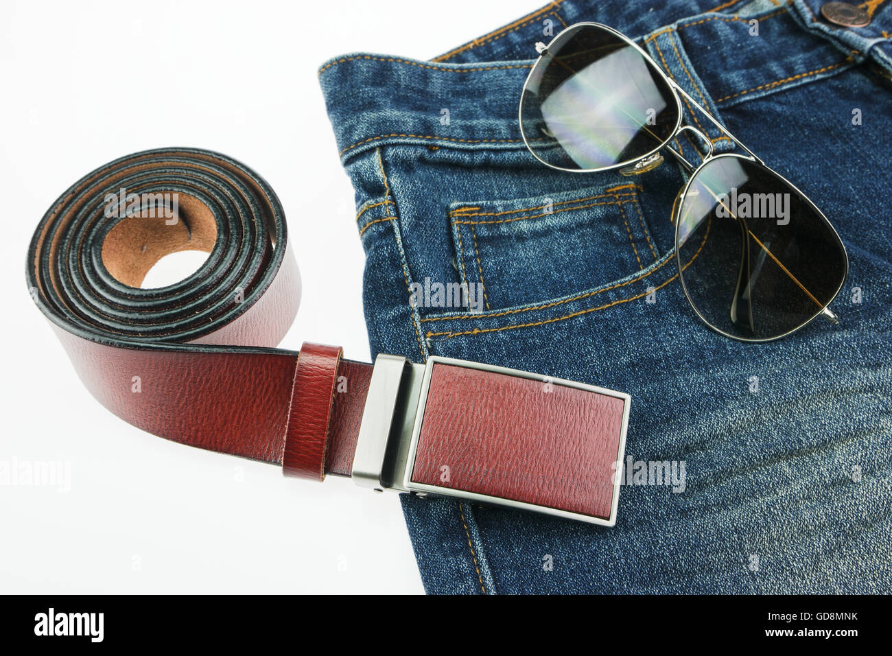 Ledergürtel, Jeans, Sonnenbrillen, die isoliert auf weißem Hintergrund Stockfoto