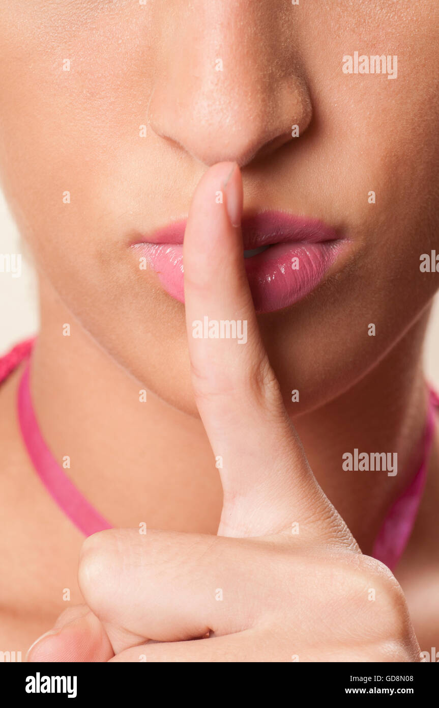 Junge Frau Hand am Mund mit Stille Geste Stockfoto