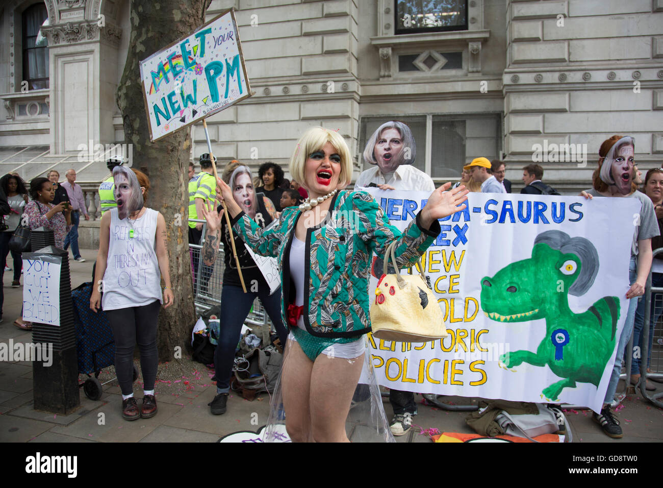 London, UK. 13. Juli 2016. Am Tag, den der neue konservative Parteichef Theresa kann MP Premierminister des Vereinigten Königreichs wurde, Demonstranten humorvoll gekleidet in Gesichtsmasken und amüsante politische Lieder singen, die spöttisch der PM vor Downing Street am 13. Juli 2016 in London, Vereinigtes Königreich. Der Anführer des Protestes verkleidet, wie ein Witz Theresa mit blonder Perücke, grob in Aufmachungen auf machen, durch Kunststoff Kleidung und tragen Perlen sehen kann, Passanten begeistert. Bildnachweis: Michael Kemp/Alamy Live-Nachrichten Stockfoto