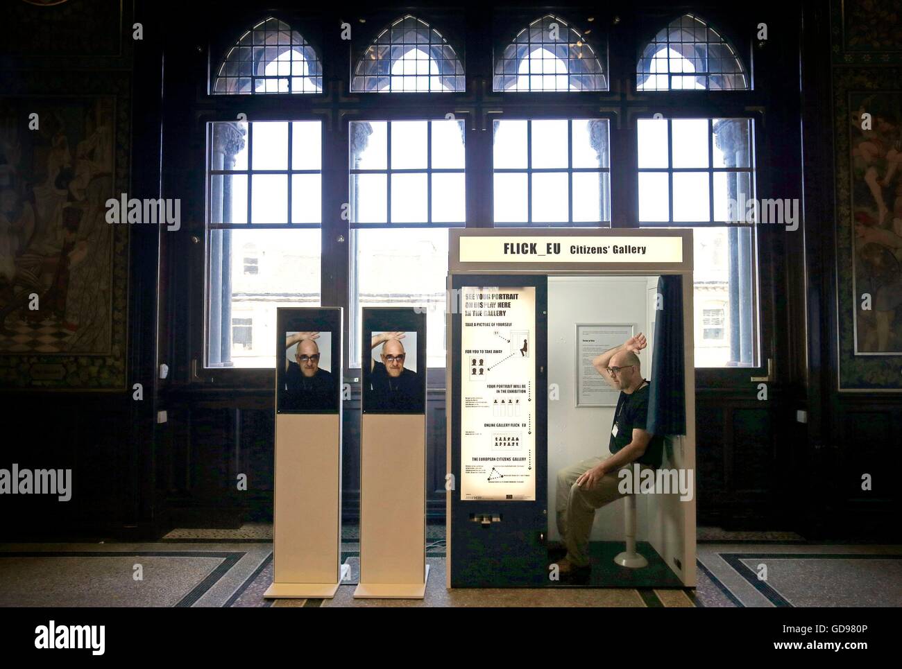 Galerie-Assistent Derek Hauffen nutzt eine Fotokabine, die Teil der FLICK EU interaktive Installation bildet, nimmt Bilder der Besucher beim Eintritt in der neuen Ausstellung mit Blick auf die Welt: Self Portrait Rembrandt bis Al Weiwei an die Scottish National Portrait Gallery in Edinburgh. Stockfoto