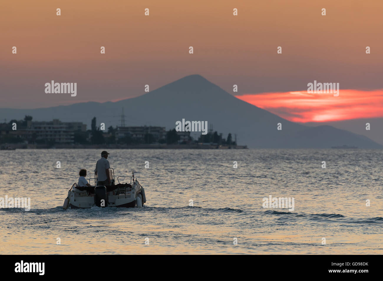 Motorboot mit ein paar darauf gegen den wunderschönen Sonnenuntergang. Stockfoto