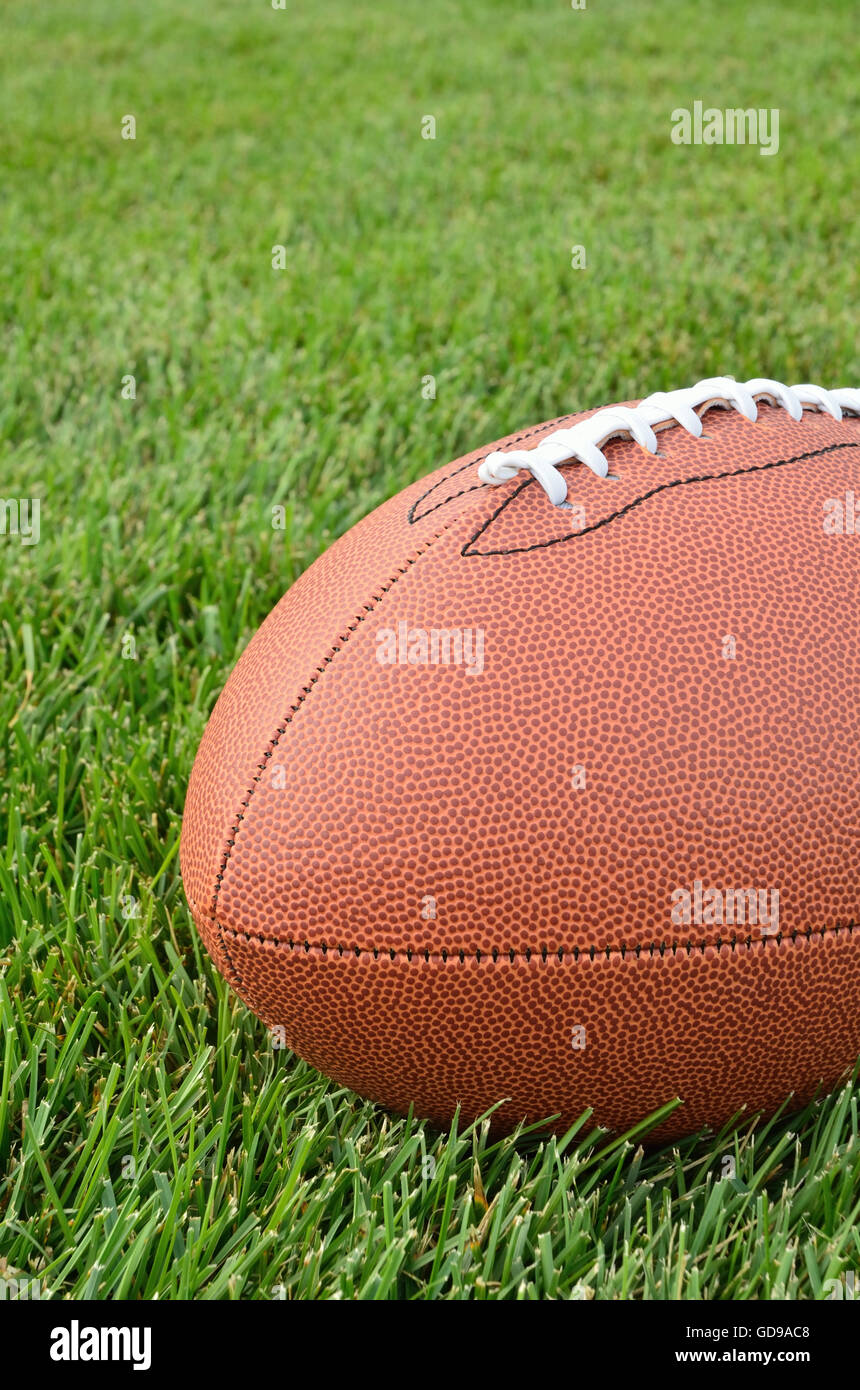 Nahaufnahme von einem American Football auf echtem Rasen Rasen eines Fußballfeldes Stockfoto