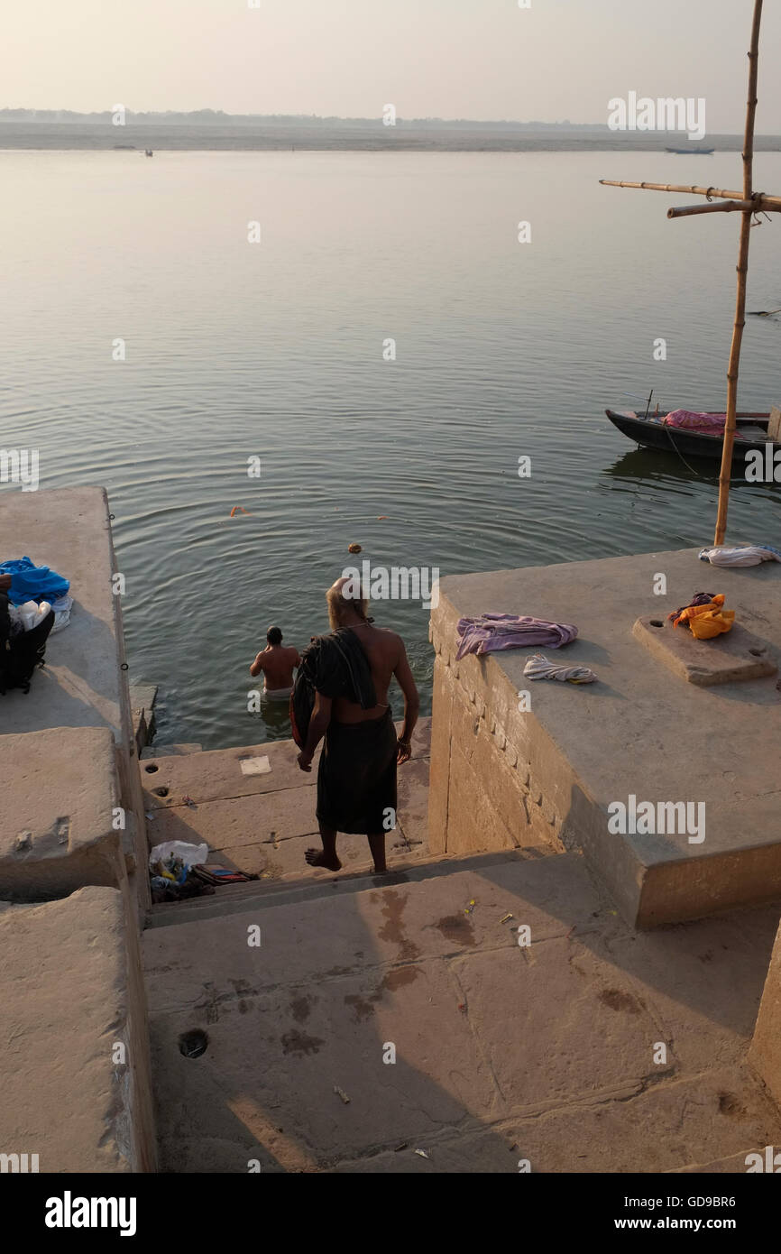 Ein Mann, Step-down, um kurz nach Sonnenaufgang in den heiligen Fluss Ganges zu Baden. Varanasi, Uttar Pradesh, Indien. Stockfoto