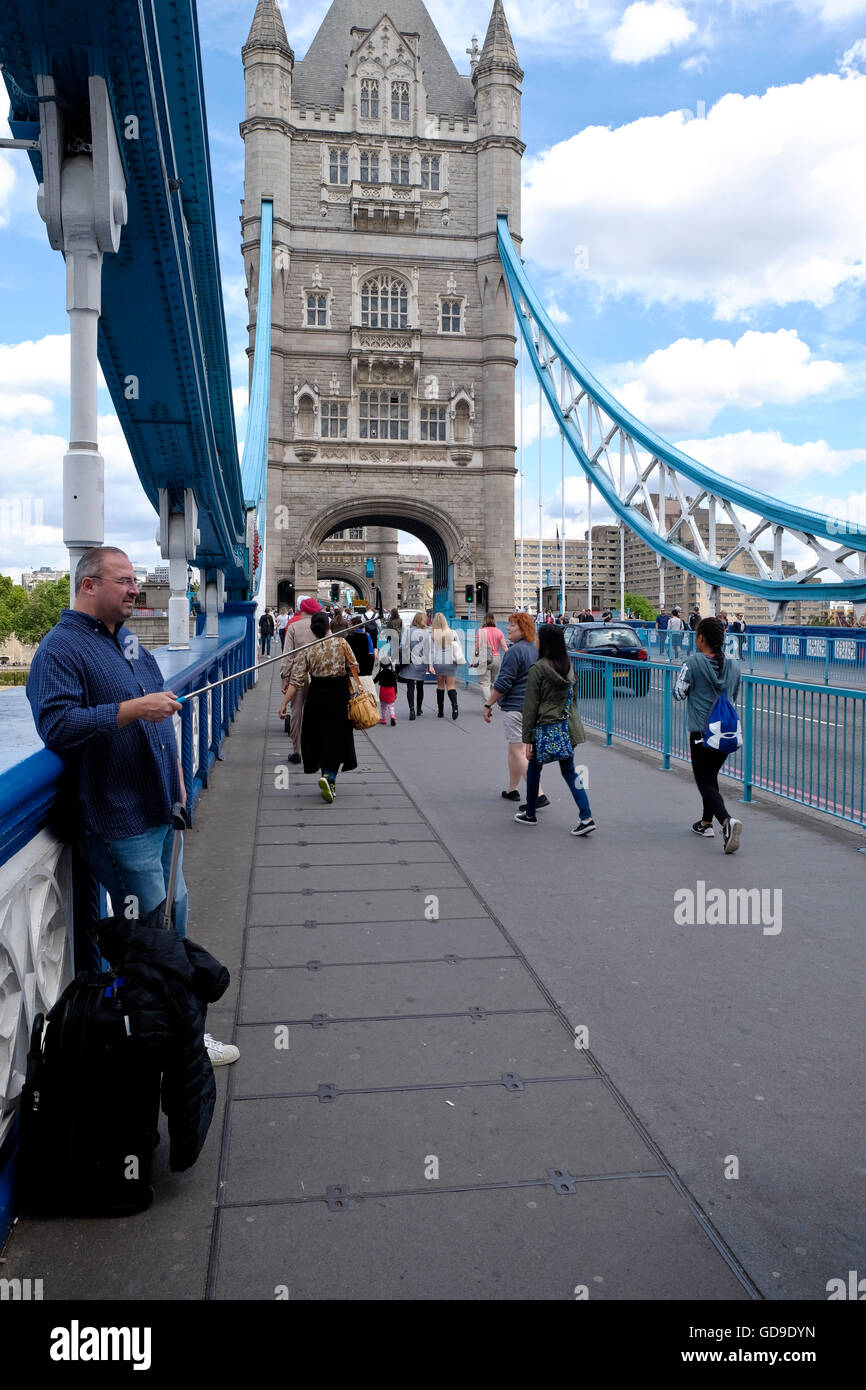 Ein Tourist nimmt ein Selbstporträt auf dem Fußgängerweg über die Tower Bridge Stockfoto