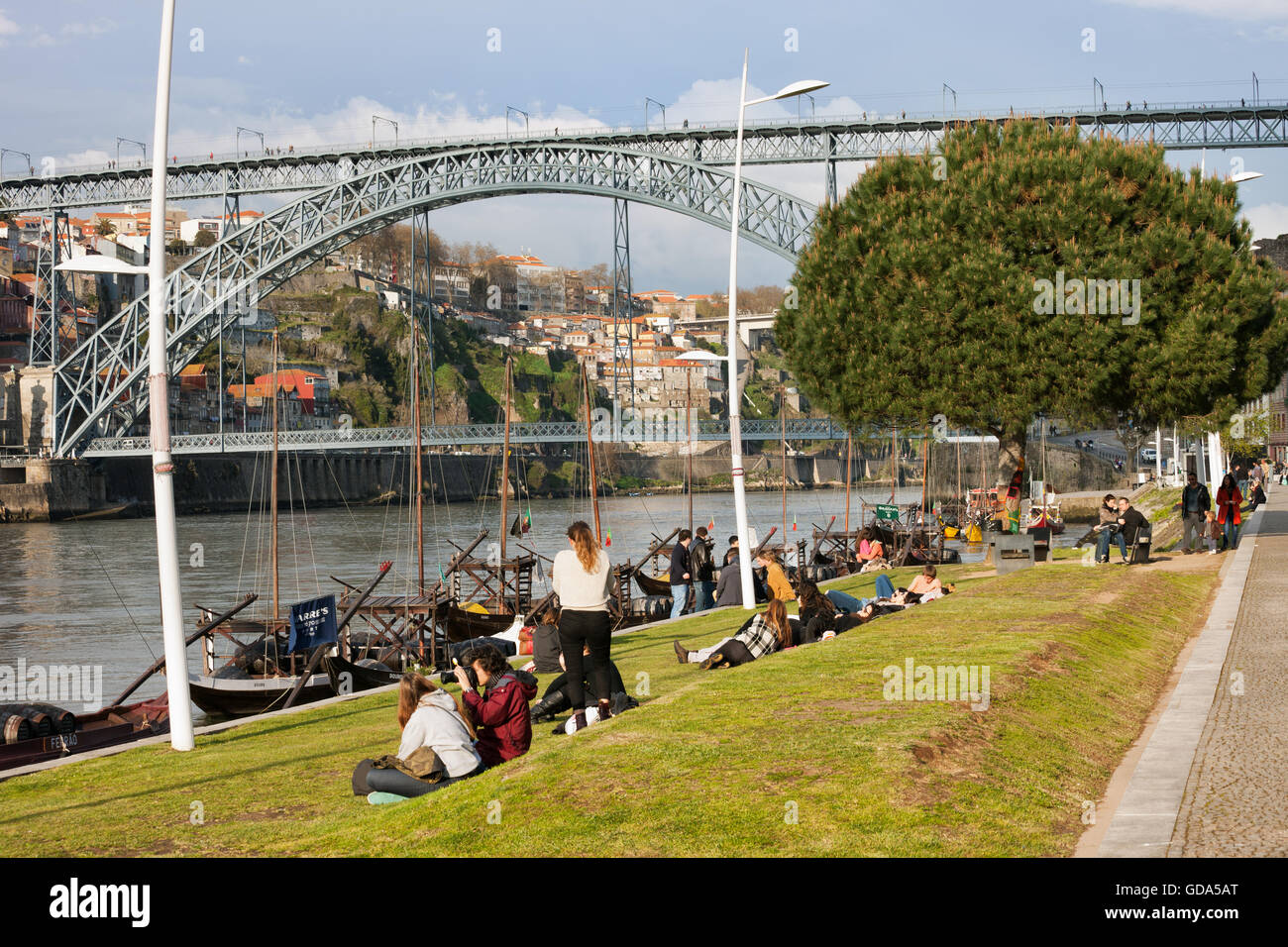 Menschen entspannen Sie am Park Rasen am Douro-Fluß in Vila Nova De Gaia und Porto in der Nähe von Dom Luis I Brücke, Wahrzeichen der Stadt Stockfoto