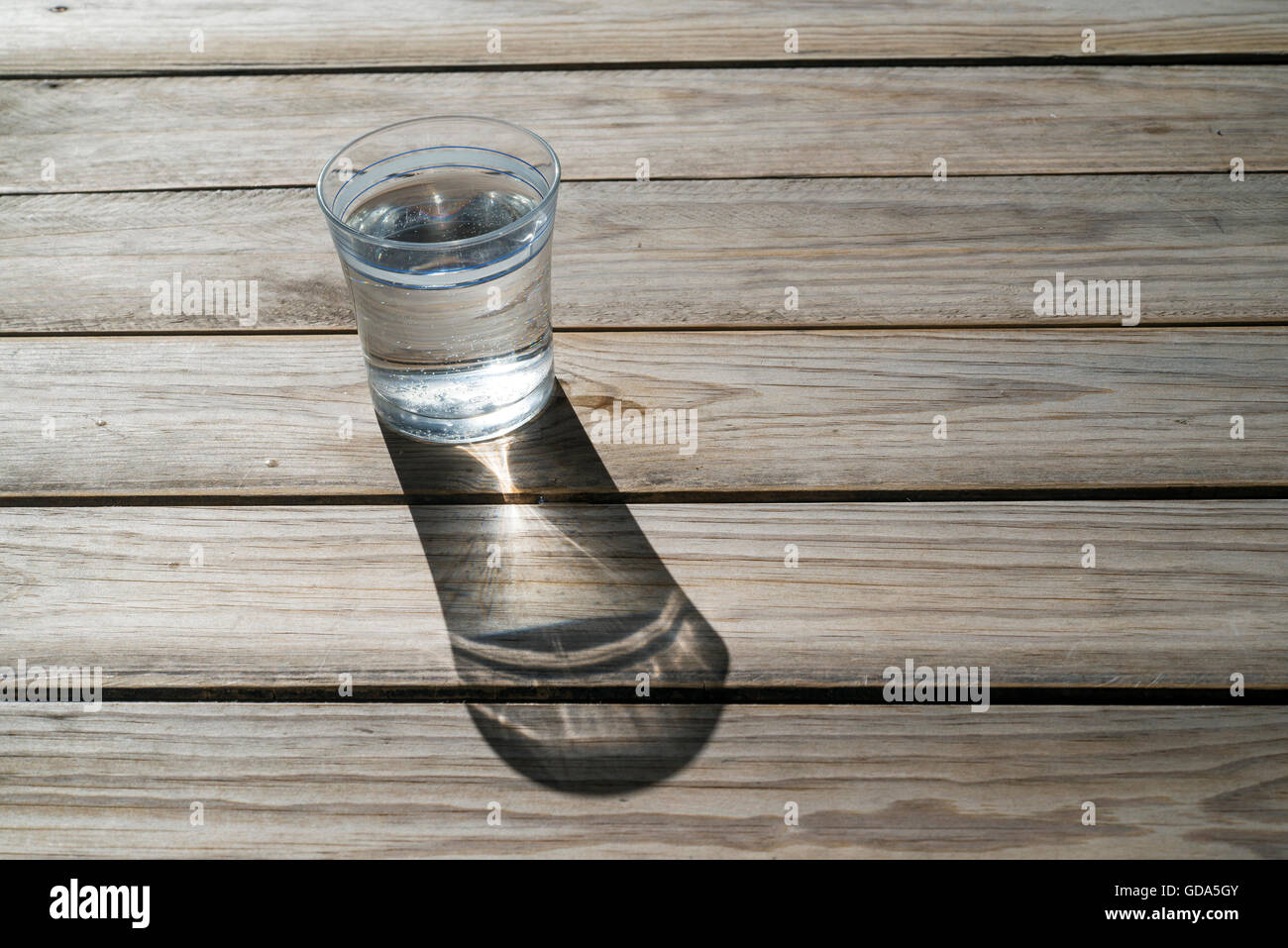 Glas Wasser auf Holz Hintergrund, um die Sonne. Textfreiraum Stockfoto
