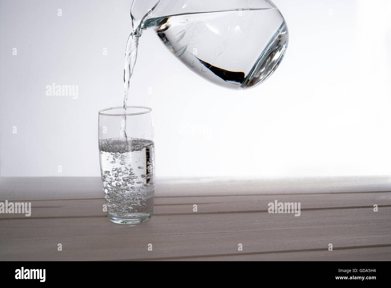 Gießen Sie Wasser aus einem Krug in ein Glas. Textfreiraum Stockfoto