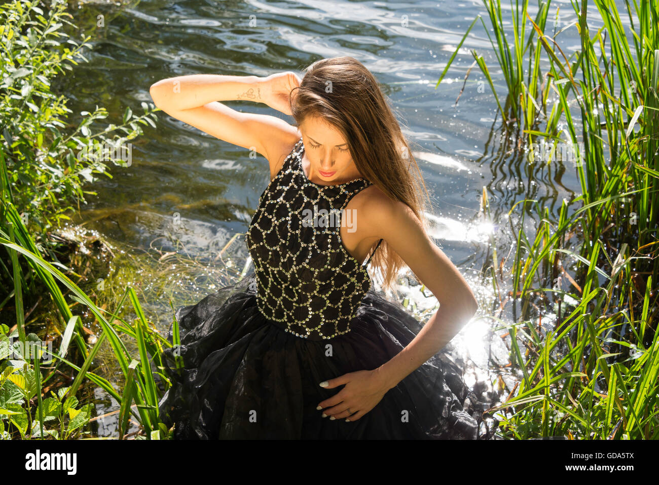 Junge weibliche Modell (20) auf Foto-Shooting im Fluss, Colnbrook, Berkshire, England, Vereinigtes Königreich Stockfoto