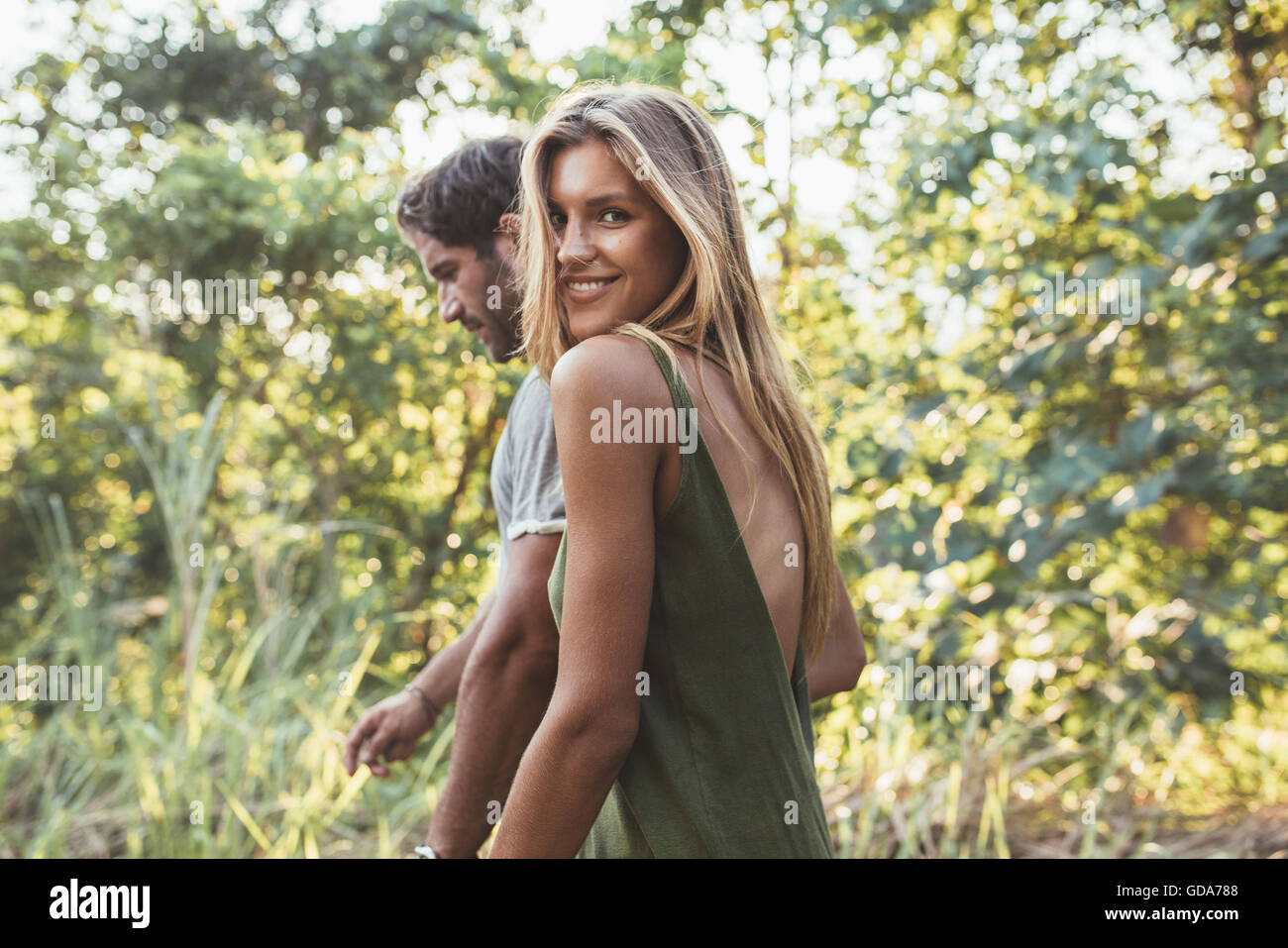 Porträt von attraktiven jungen Frau zu Fuß mit ihrem Freund im Freien. Junges Paar zusammen, in der Landschaft. Stockfoto