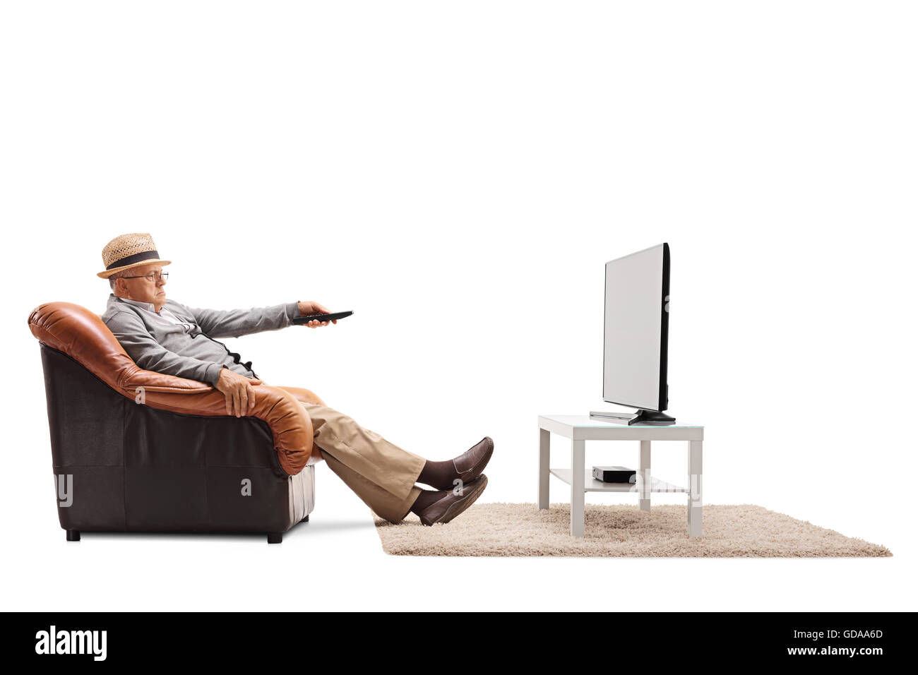 Gelangweilt Senior Senderwechsel auf seinem Fernseher sitzt auf einem Sessel isoliert auf weißem Hintergrund Stockfoto