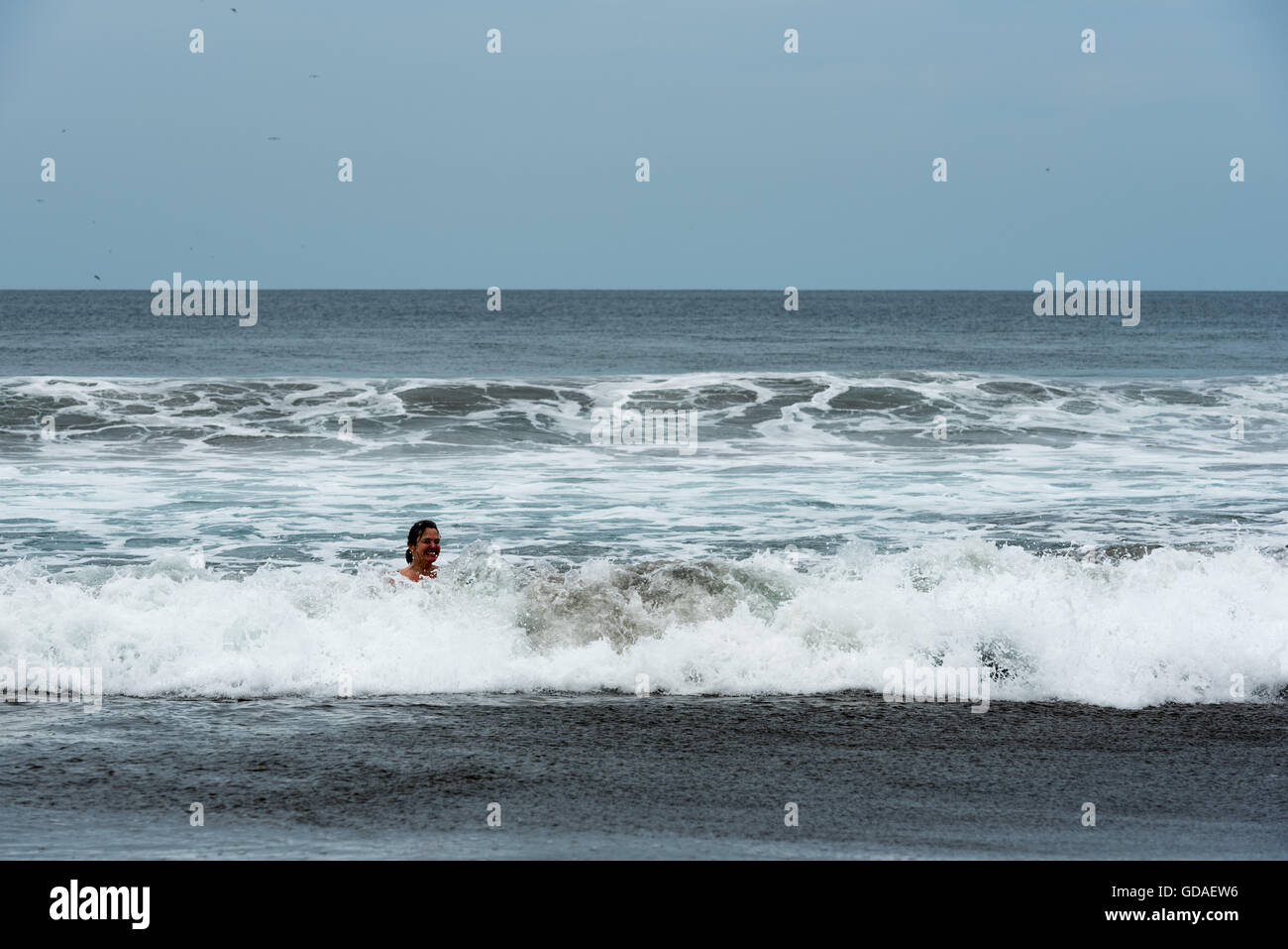 Costa Rica, Guanacaste, Playa Junquillal Frau im Regen im Meer schwimmt Stockfoto
