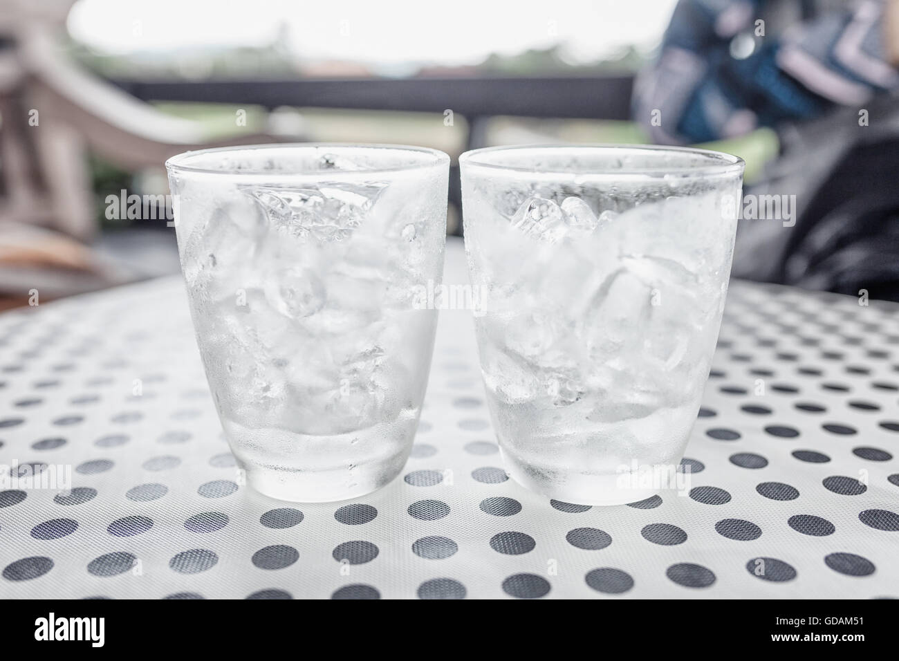 Gläser mit Eiswürfeln auf schwarzen Punkt Hintergrund Tisch. Stockfoto