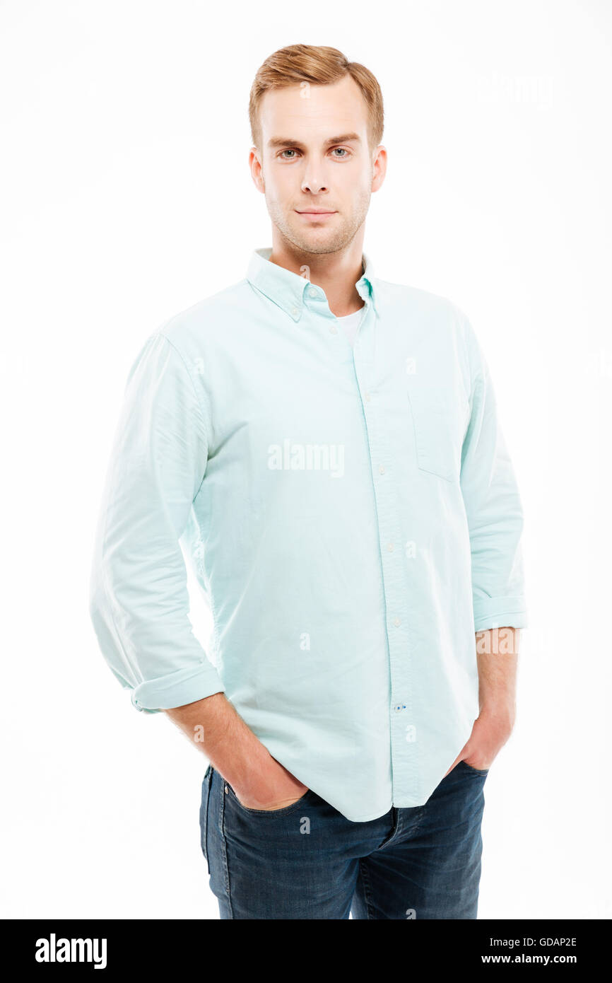 Nahaufnahme von schweren attraktive junge Mann stehend mit Händen in den Taschen auf weißem Hintergrund Stockfoto