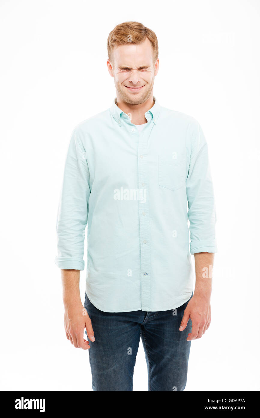 Netten junge Mann lächelnd und Schielen auf weißem Hintergrund Stockfoto