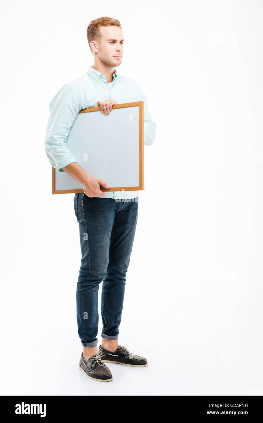 Volle Länge des schweren rothaarige junge Mann stehen und halten whiteboard Stockfoto