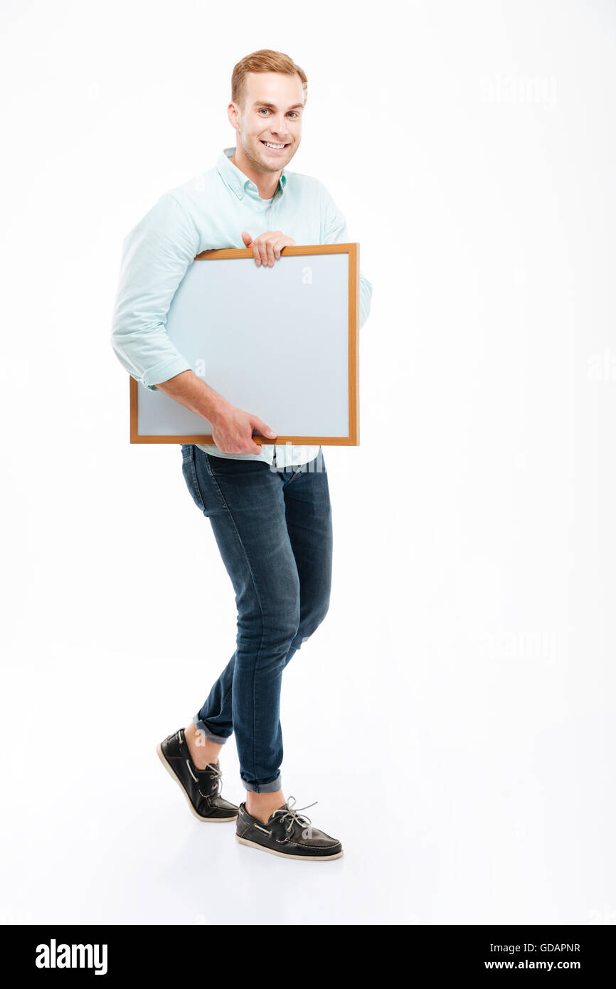Volle Länge des fröhlichen afrikanischen jungen Mann zu Fuß und hält whiteboard Stockfoto
