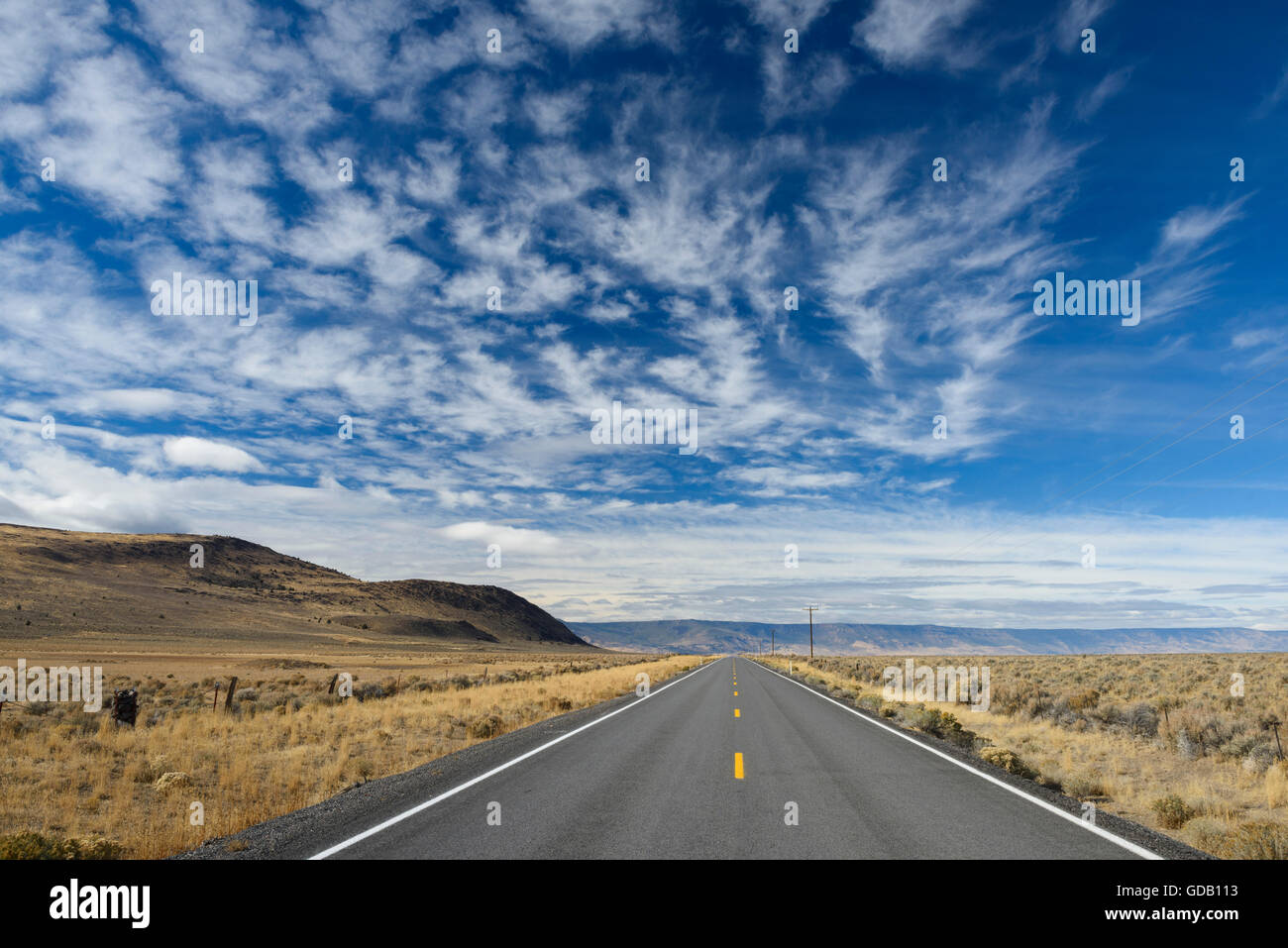 USA, Ost-Oregon, einsame Landstraße im östlichen Oregon mit Wolken Stockfoto