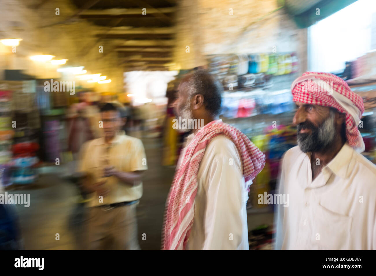 Männer in traditionelle arabische Kleidung Wandern Sie durch die Gassen von Doha Souq Waqif. Stockfoto