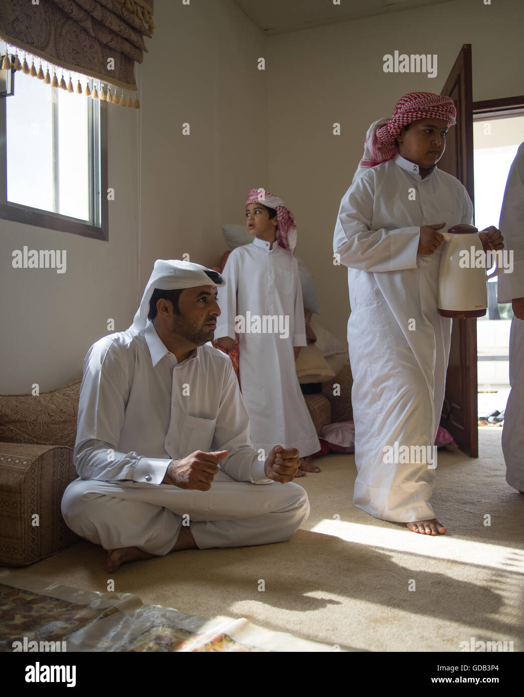 Katar Mann und seine Söhne auf ihren Bauernhof Majlis, Vorbereitung für ein großes Rennen auf die Kamelrennen verfolgen, Al Shahiniya, nördlich von Doha, Katar. Stockfoto