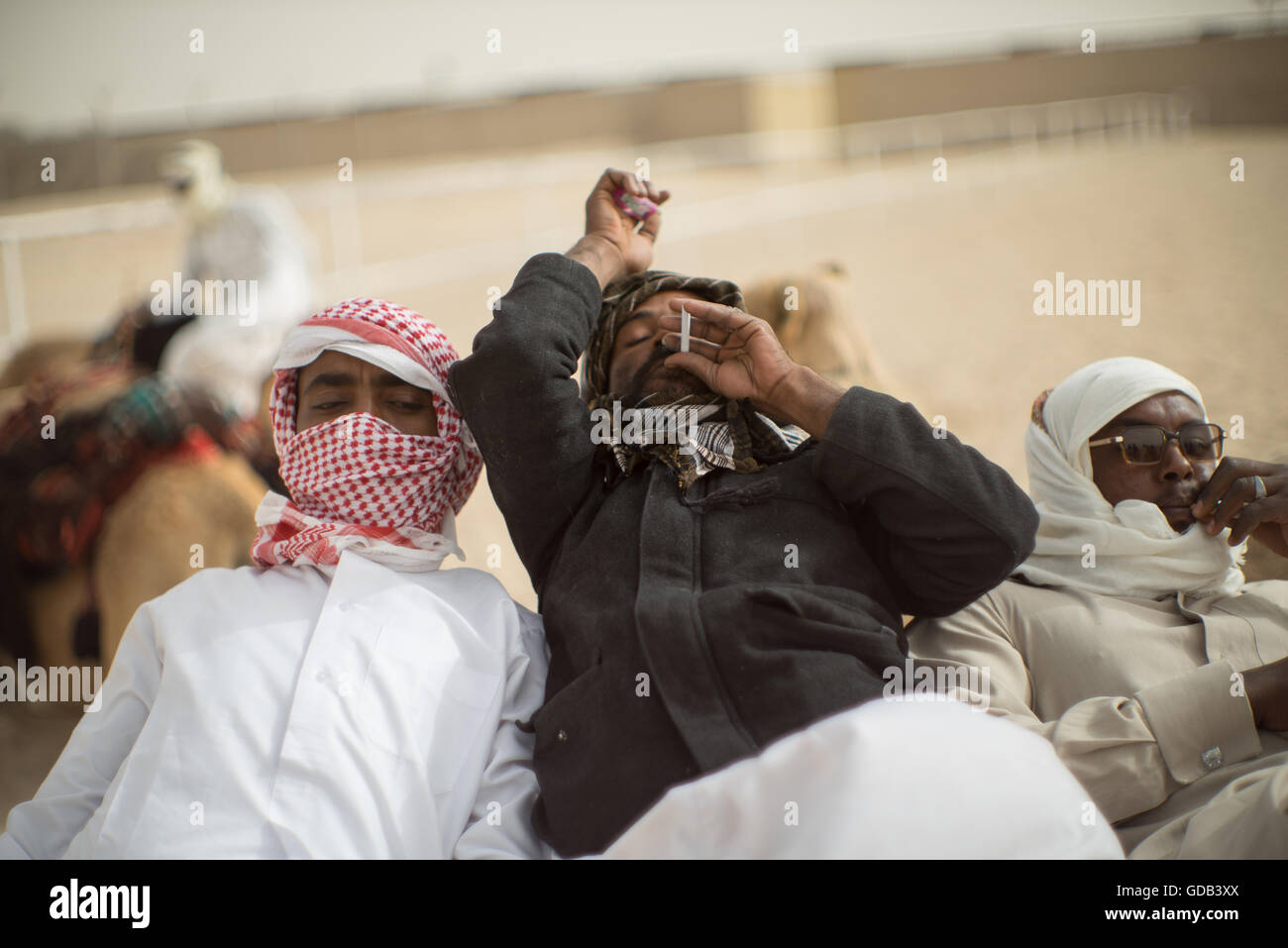 Kamel Trainer nehmen eine Auszeit, Kamel-Farm in der Nähe das Kamel-Rennstrecke, Al Shahiniya, nördlich von Doha, Katar. Stockfoto