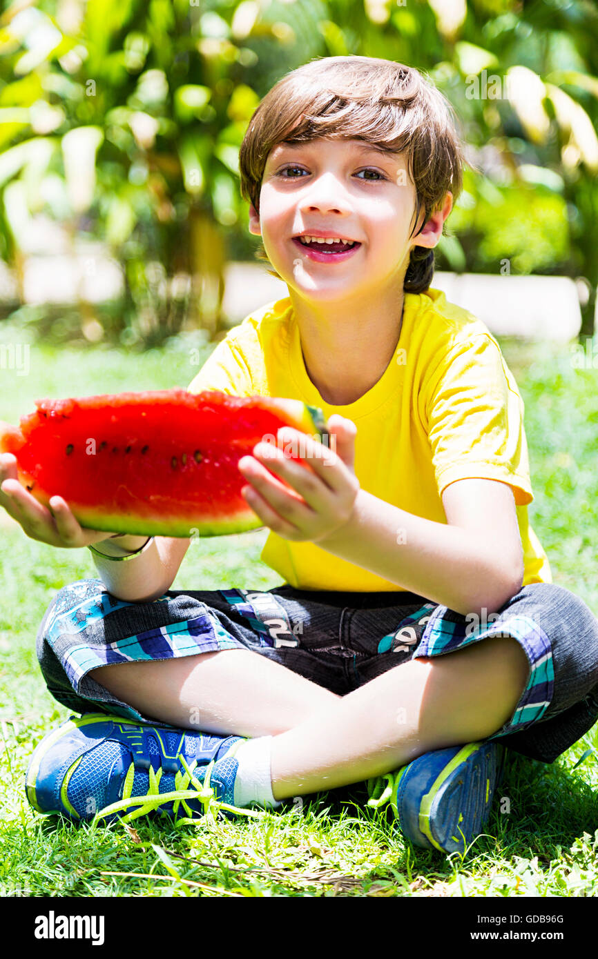 1 Kind Indianerjunge Parken Wassermelone essen Obst Stockfoto