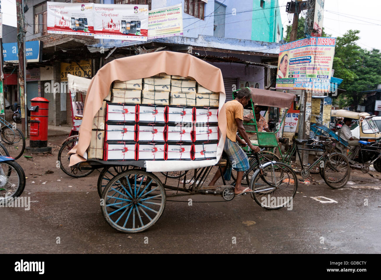 Zyklus-Rikscha-Fahrer mit voller Last-Boxen in Agra, Uttar Pradesh, Indien Stockfoto