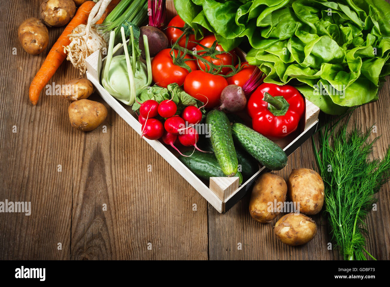 Frisches Gemüse in Holzkiste auf rustikalen Hintergrund Stockfoto