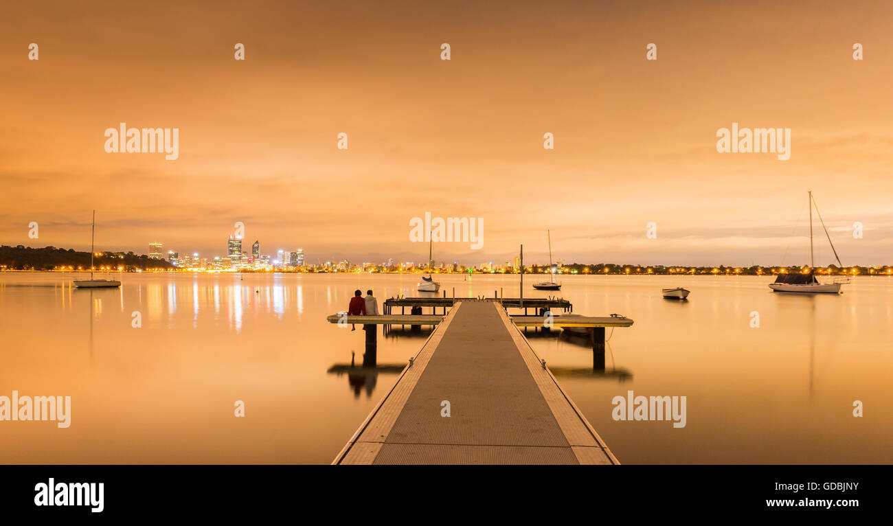 Ein Pärchen beobachten Sonnenaufgang am Matilda Bay, Western Australia, Australien Stockfoto