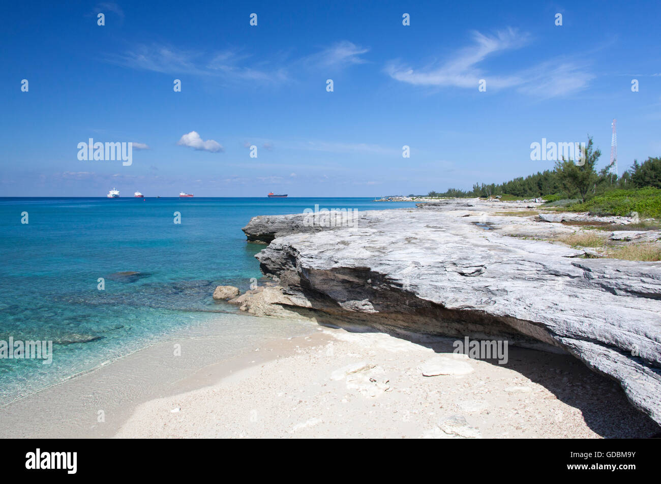 Erodierte Strand in Freeport mit Cargo Schiffe im Hintergrund (Grand Bahama Island). Stockfoto