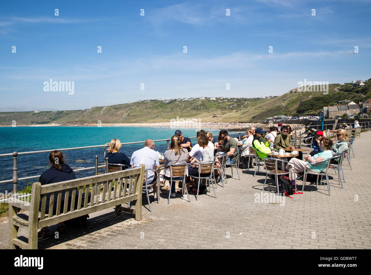 Leute sitzen im Freien an Café-Tischen von Meer, Sennan Cove, Endland, Cornwall, England, UK Stockfoto