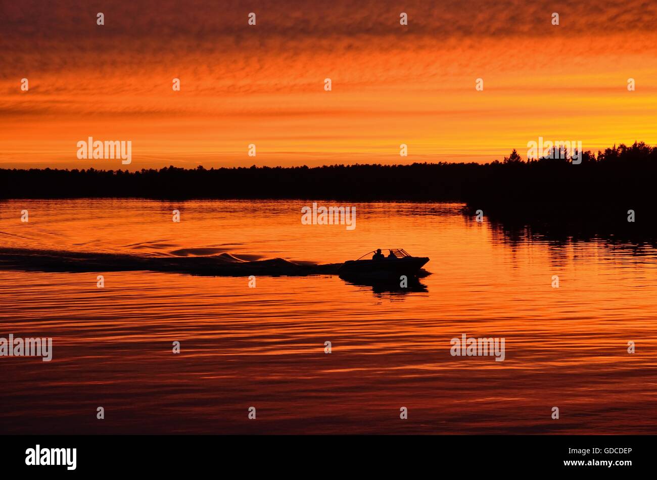 Boot fahren nach Sonnenuntergang auf einem ruhigen See Stockfoto