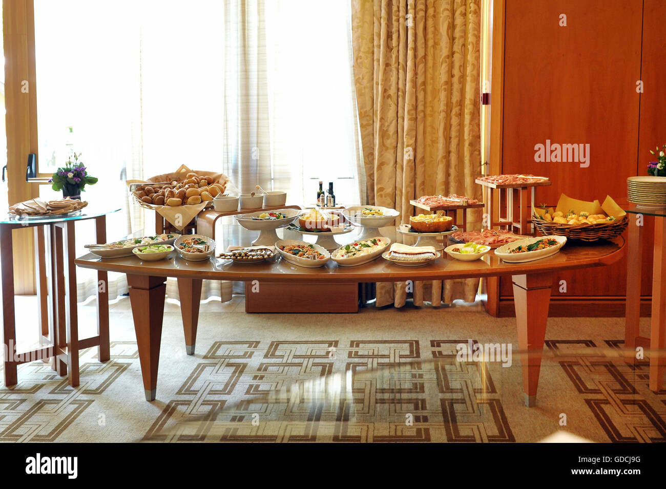 Buffet-Tisch mit einer Auswahl an Speisen in einem Restaurant oder Hotel mit kalten Mets, Fisch und Salate vor einem großen Fenster Stockfoto