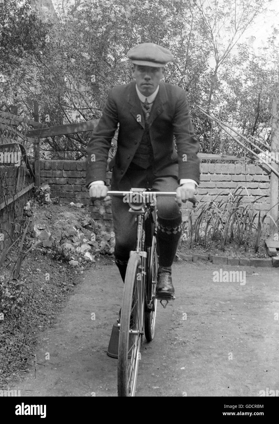 Mann in flache Kappe auf dem Fahrrad c1920. Foto von Tony Henshaw Stockfoto