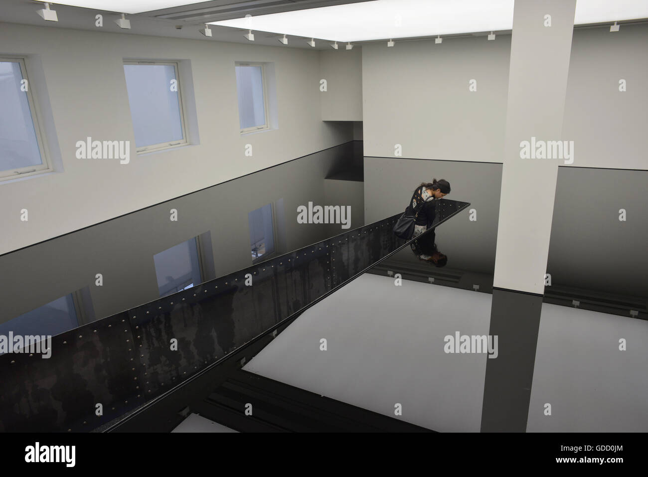 Frau sieht ihr Spiegelbild in Öl-Installation von Richard Wilson in der Saatchi gallery Stockfoto
