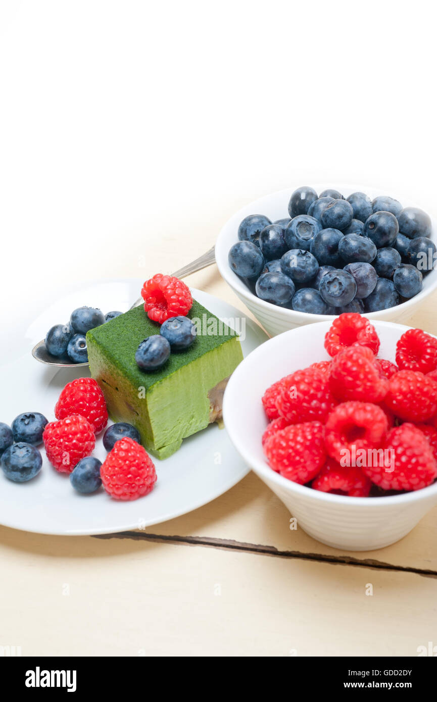 Grüner Tee Matcha Mousse Torte mit Himbeeren und Heidelbeeren an der Spitze Stockfoto