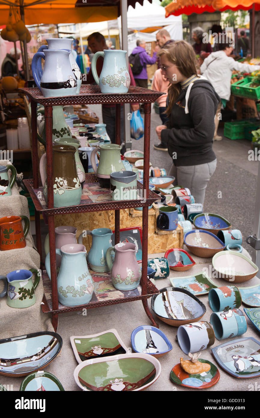 Irland, Co. Galway, Galway, Samstag Markt, Frau Shopper Blick auf Keramik-stall Stockfoto