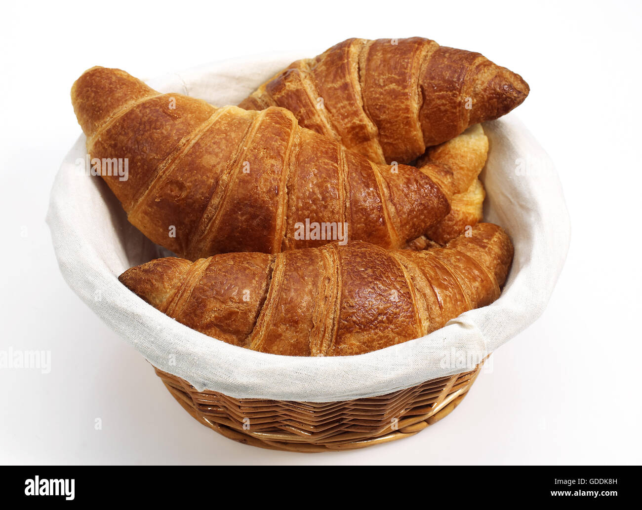 CROISSANTS IN KORB VOR WEIßEM HINTERGRUND Stockfoto