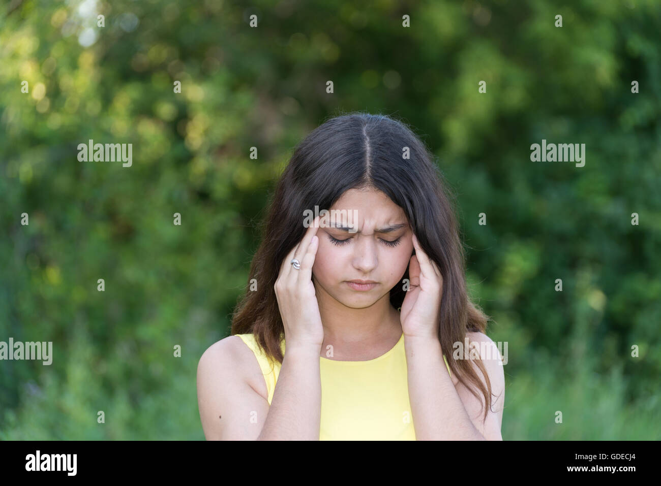 Teengirl mit Migräne im Freien im Sommer Stockfoto
