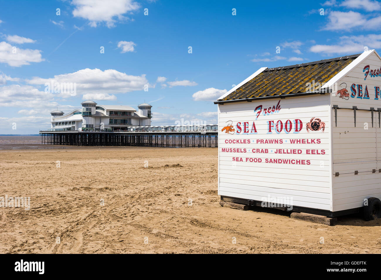 Ein Meeresfrüchte-Stall am Strand von Weston-super-Mare mit dem Grand Pier hinter North Somerset, England. Stockfoto
