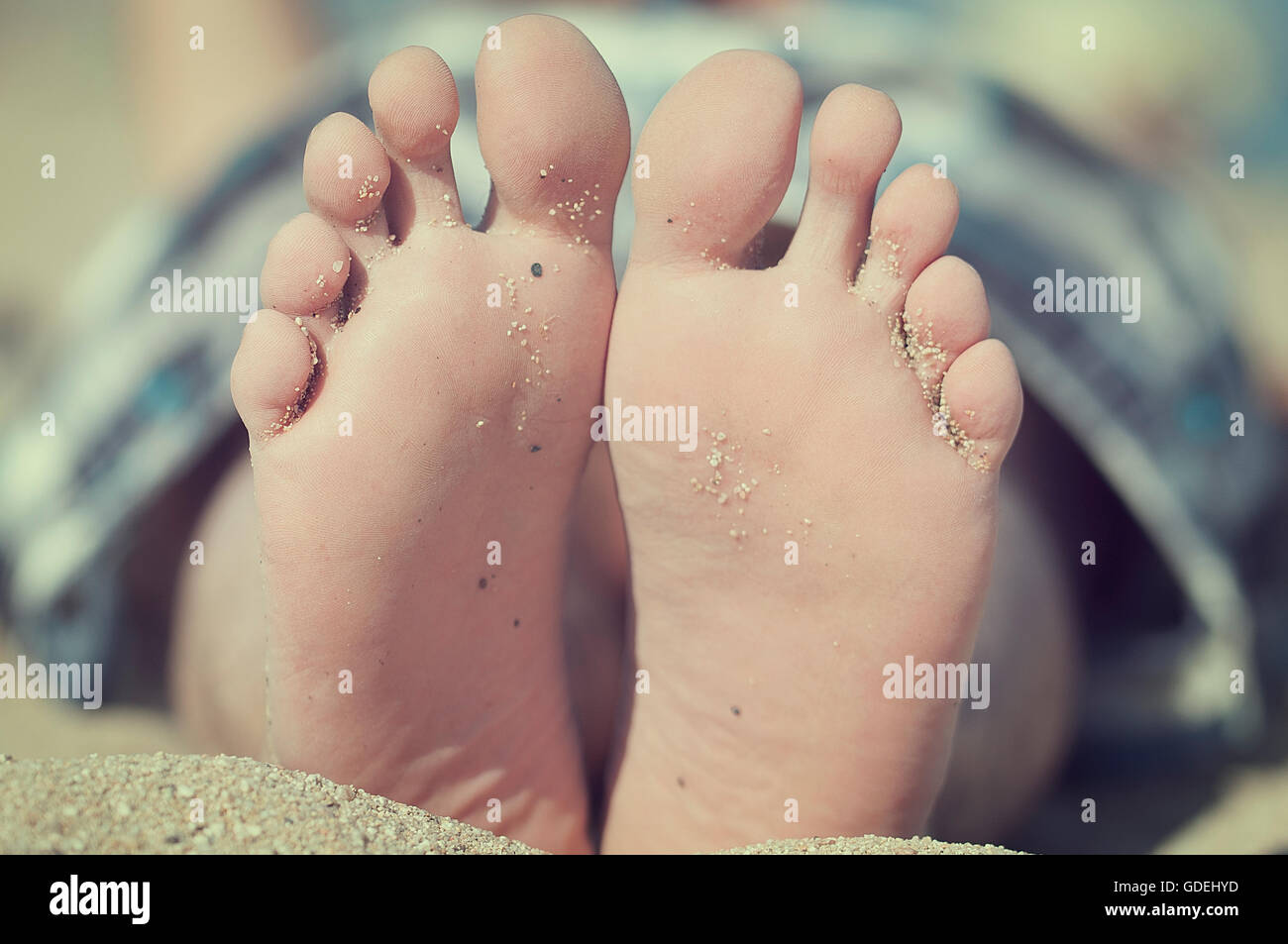 Nahaufnahme der Füße im Sand am Strand Stockfoto