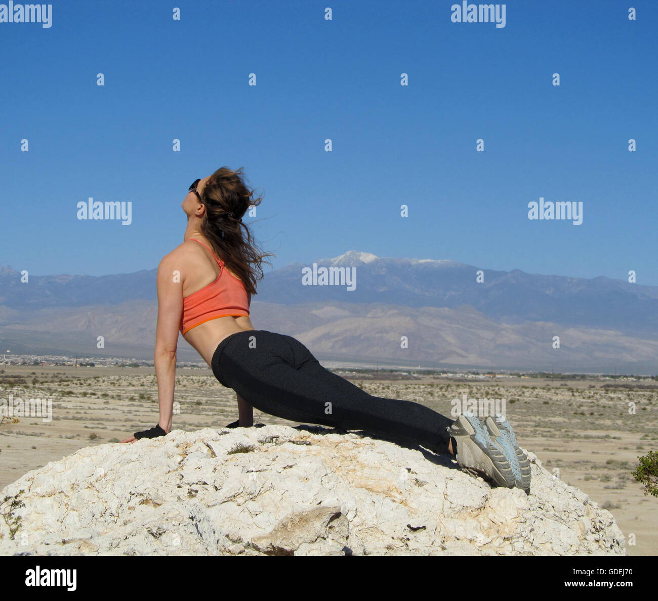 Frau, die einen nach oben gerichteten Hund Yoga Pose auf einem Felsen in der Wüste, Nevada, Vereinigte Staaten tut Stockfoto